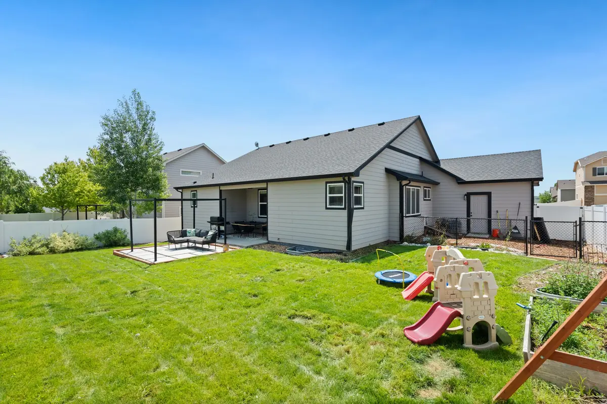 Family backyard with green lawn, patio, and play set