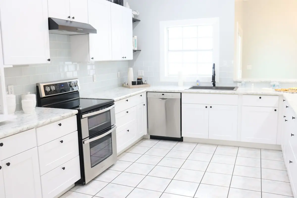 Bright white kitchen with countertops and tile floor where ant trails often appear